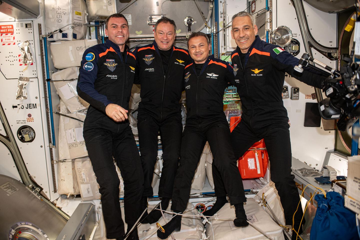 Vier männliche Astronauten stehen nebeneinander