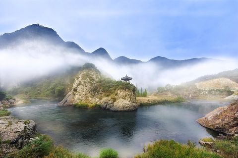 Südkorea, See im Nebel, im Bild Hintergrund ein Berg, auf dem sich ein kleiner Tempel befindet