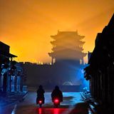 Zwei Mopeds vor einem Tempel in einer nebligen Nacht