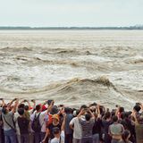 Leute, die die großen Wellen des Flusses Qiantang beobachten und fotografieren