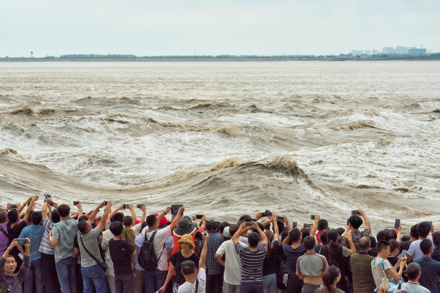 Gezeitenwelle im Qiantang: Der "Silberne Drache" Leute, die die großen Wellen des Flusses Qiantang beobachten und fotografieren