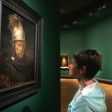 Frau schaut sich den "Mann mit dem Goldhelm" in der Galerie an