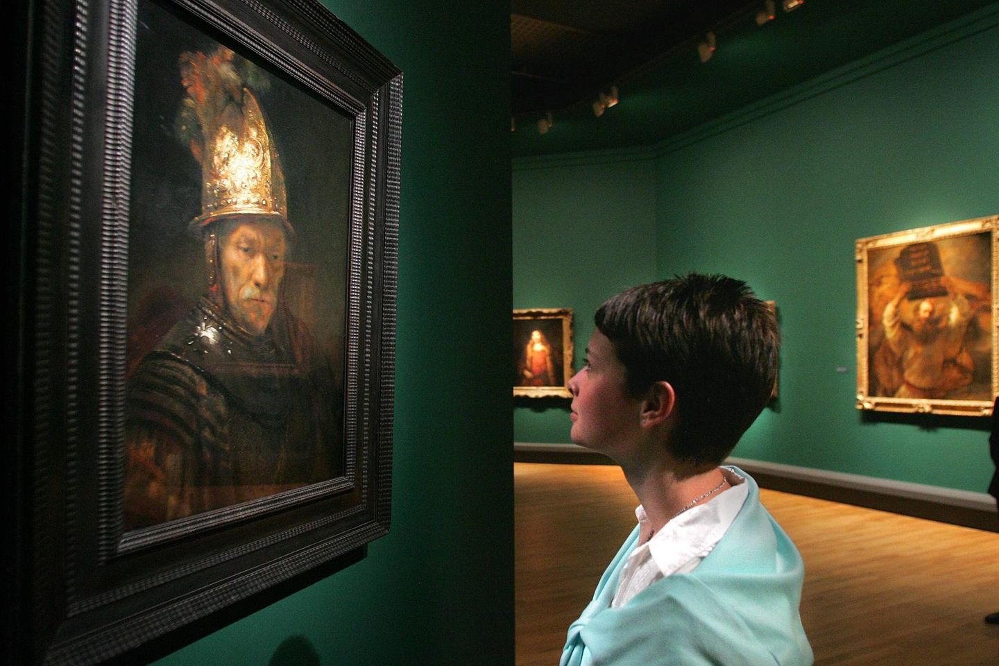 Frau schaut sich den "Mann mit dem Goldhelm" in der Galerie an