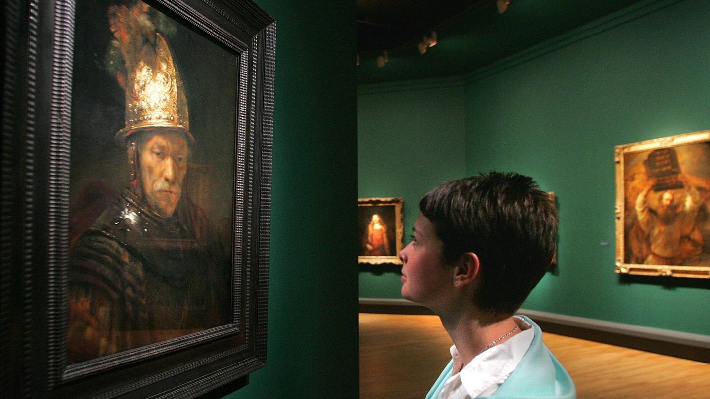 Frau schaut sich den "Mann mit dem Goldhelm" in der Galerie an
