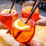 Drei Gläser mit Aperol Spritz im Sonnenlicht