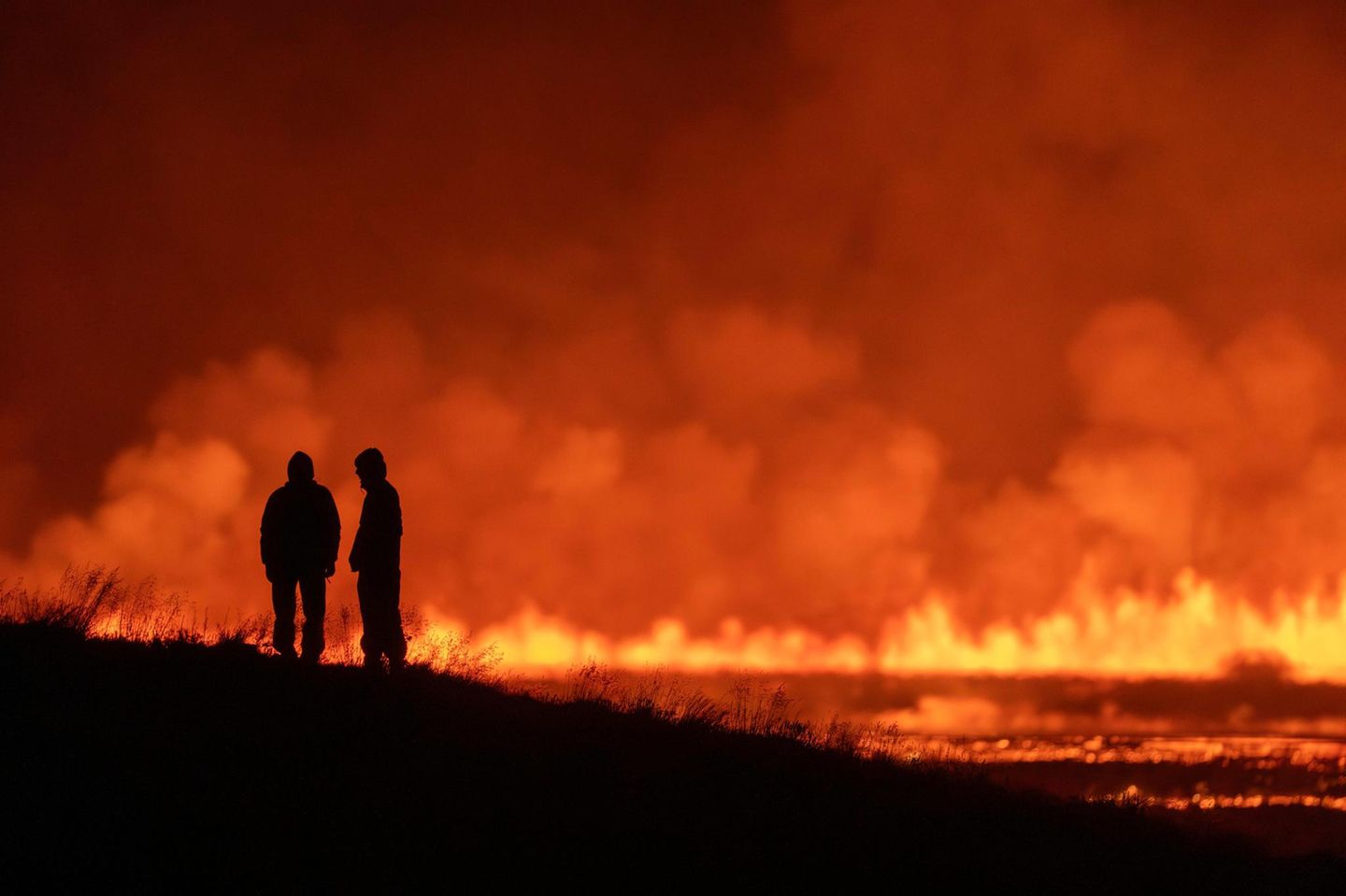 Zwei Menschen bestaunen den Vulkanausbruch auf Island