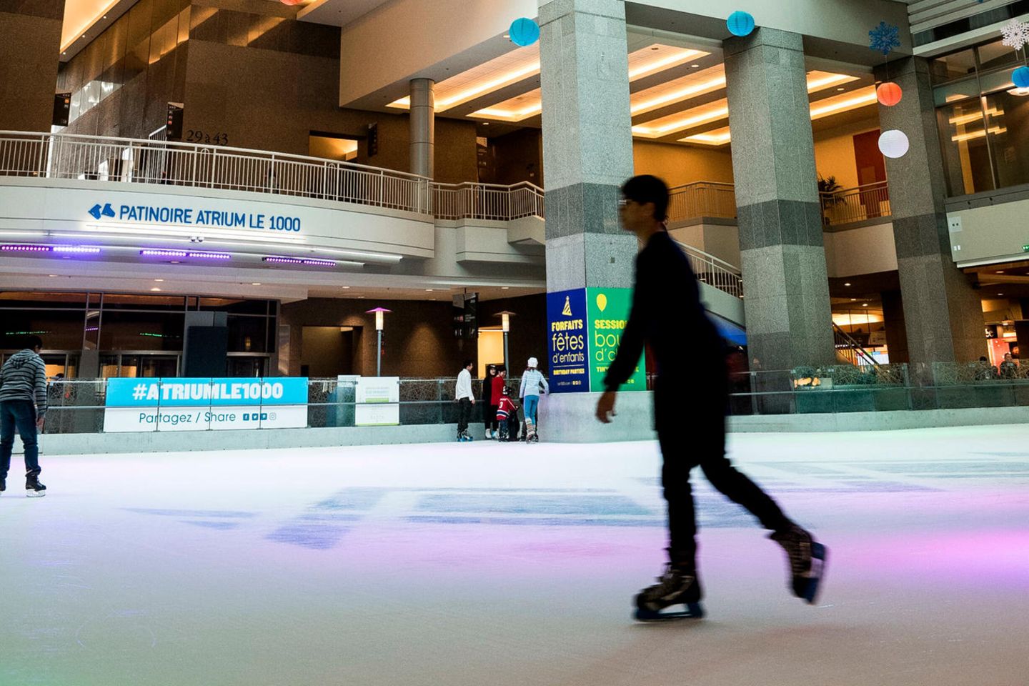 Menschen beim Eislaufen auf der Eisbahn mit der Kuppel darüber