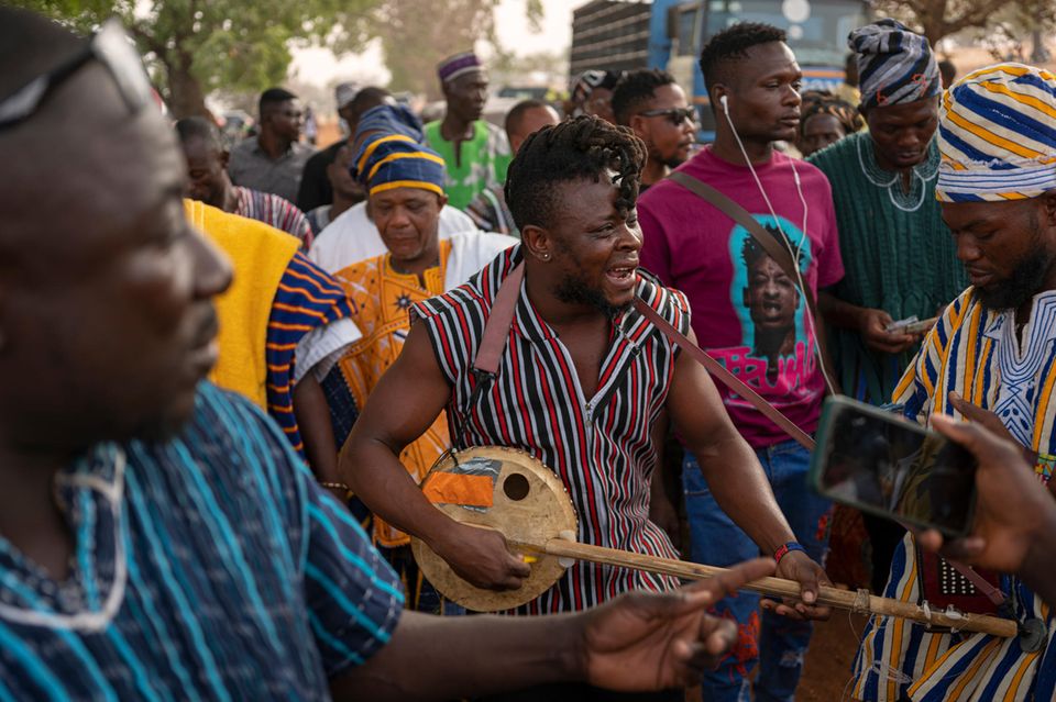Der Musiker Stevo Atambire verdient sein Geld als Beerdigungssänger in Ghana. Für seine Lieder mixt er mit seiner Kologo regional typische Rhythmen mit Hip-Hop und Reggae. Bei den Bestattungen wird er umringt von Trauernden und Fans 1.3333