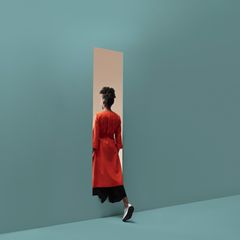 Eine Frau wandert durch eine imaginäre Wand von Raum zu Raum
