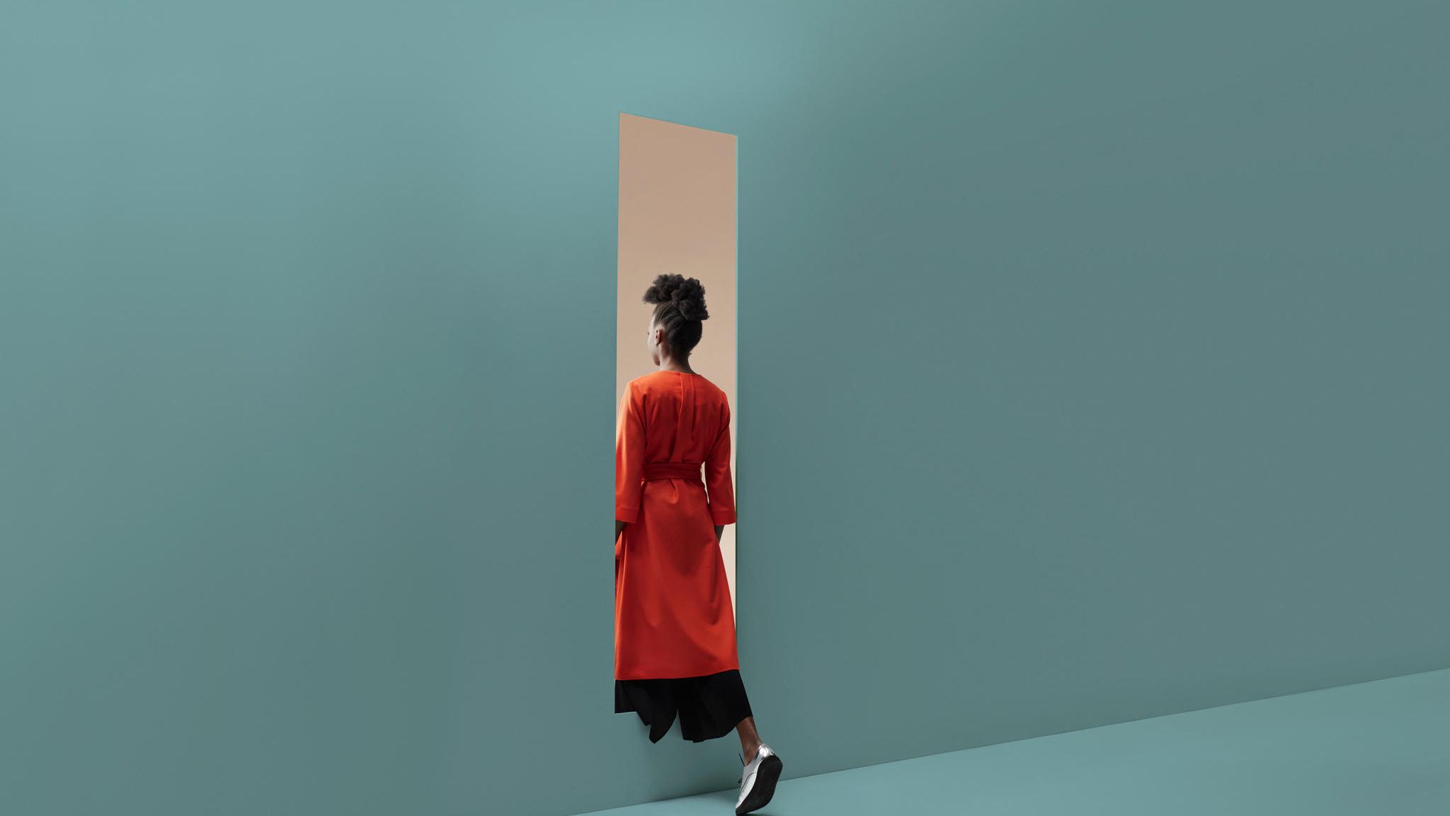 Eine Frau wandert durch eine imaginäre Wand von Raum zu Raum
