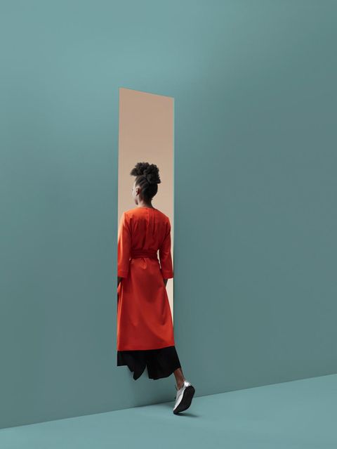 Eine Frau wandert durch eine imaginäre Wand von Raum zu Raum