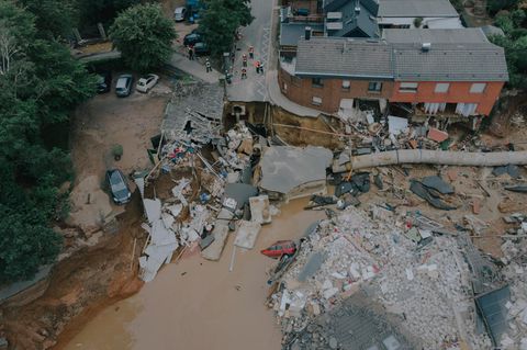 Luftaufnahme von zerstoerten Haeusern, Straßen und Autos.