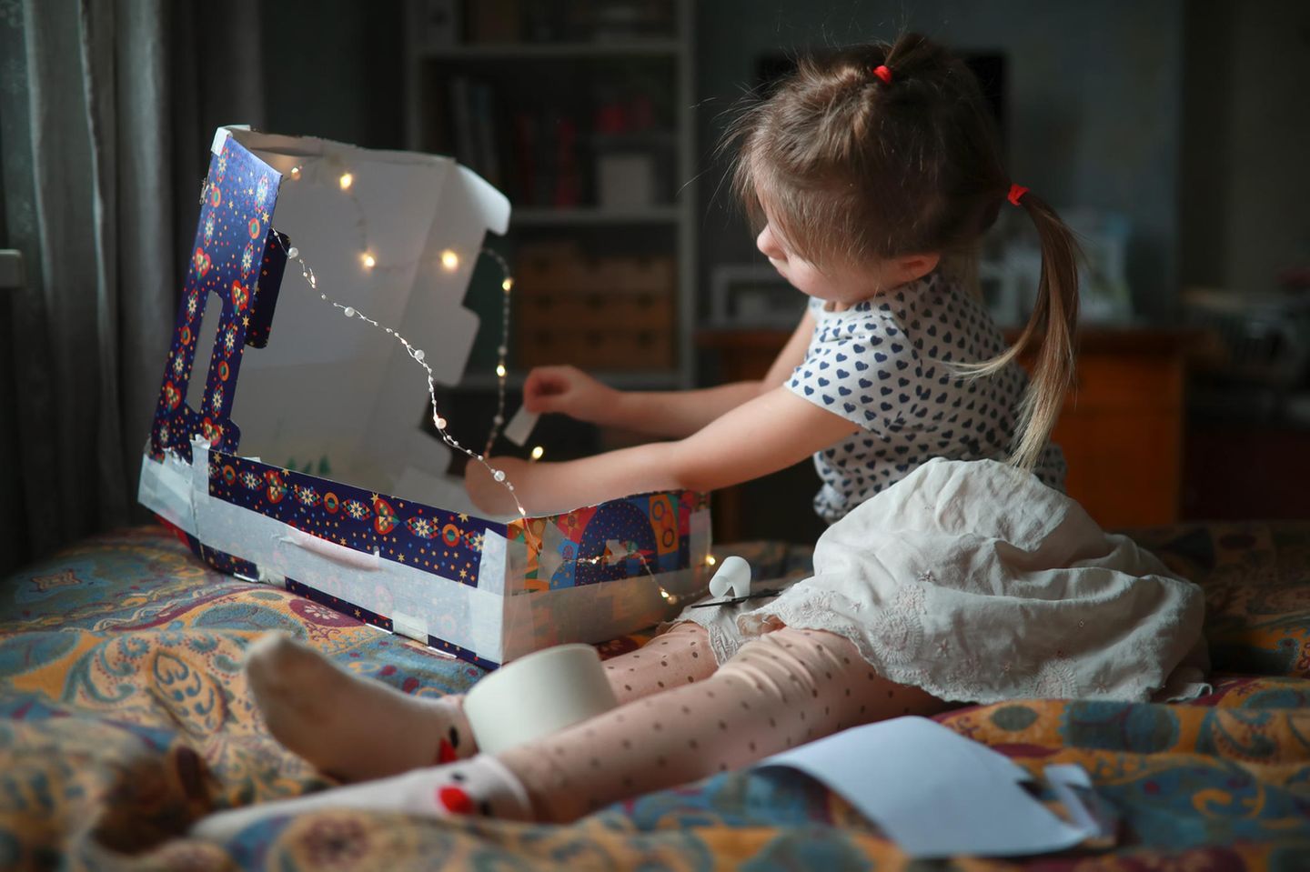 Das kreative Kinderzimmer: Ein Ort zum Träumen, Spielen und Basteln ein kleines Mädchen, das mit einer dekorierten Kartonschachtel spielt