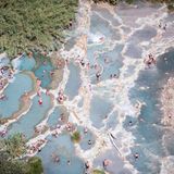 Ein Blick auf Thermalquellen der Terme di Saturnia und Menschen schwimmen darin