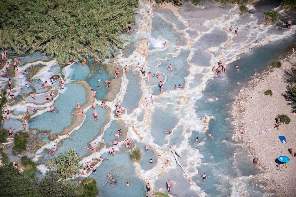 Ein Blick auf Thermalquellen der Terme di Saturnia und Menschen schwimmen darin