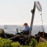 Ein Künstler, der auf Felsen der Monhegan-Insel malt
