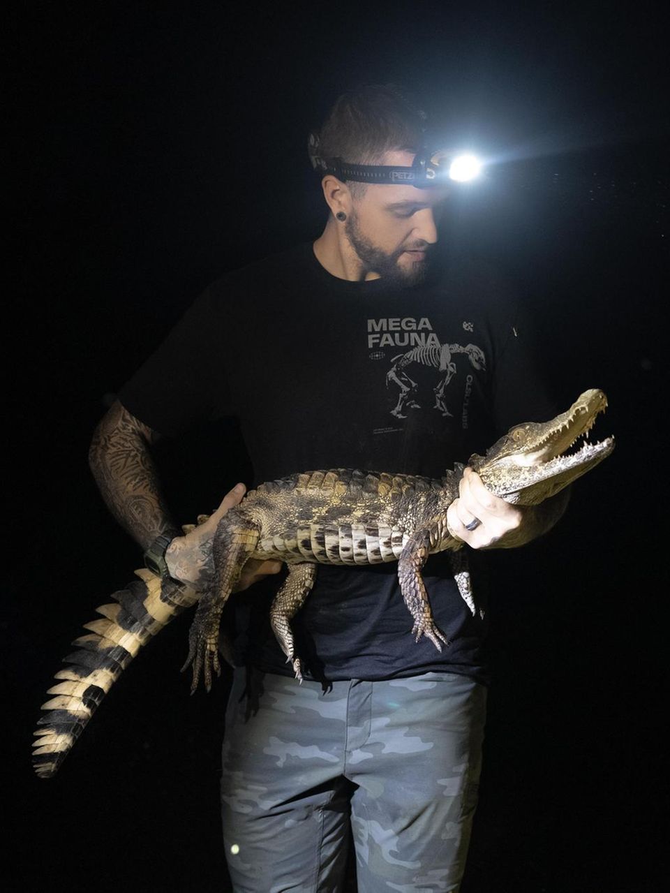 Dylan Singer hält einen kleinen Alligator