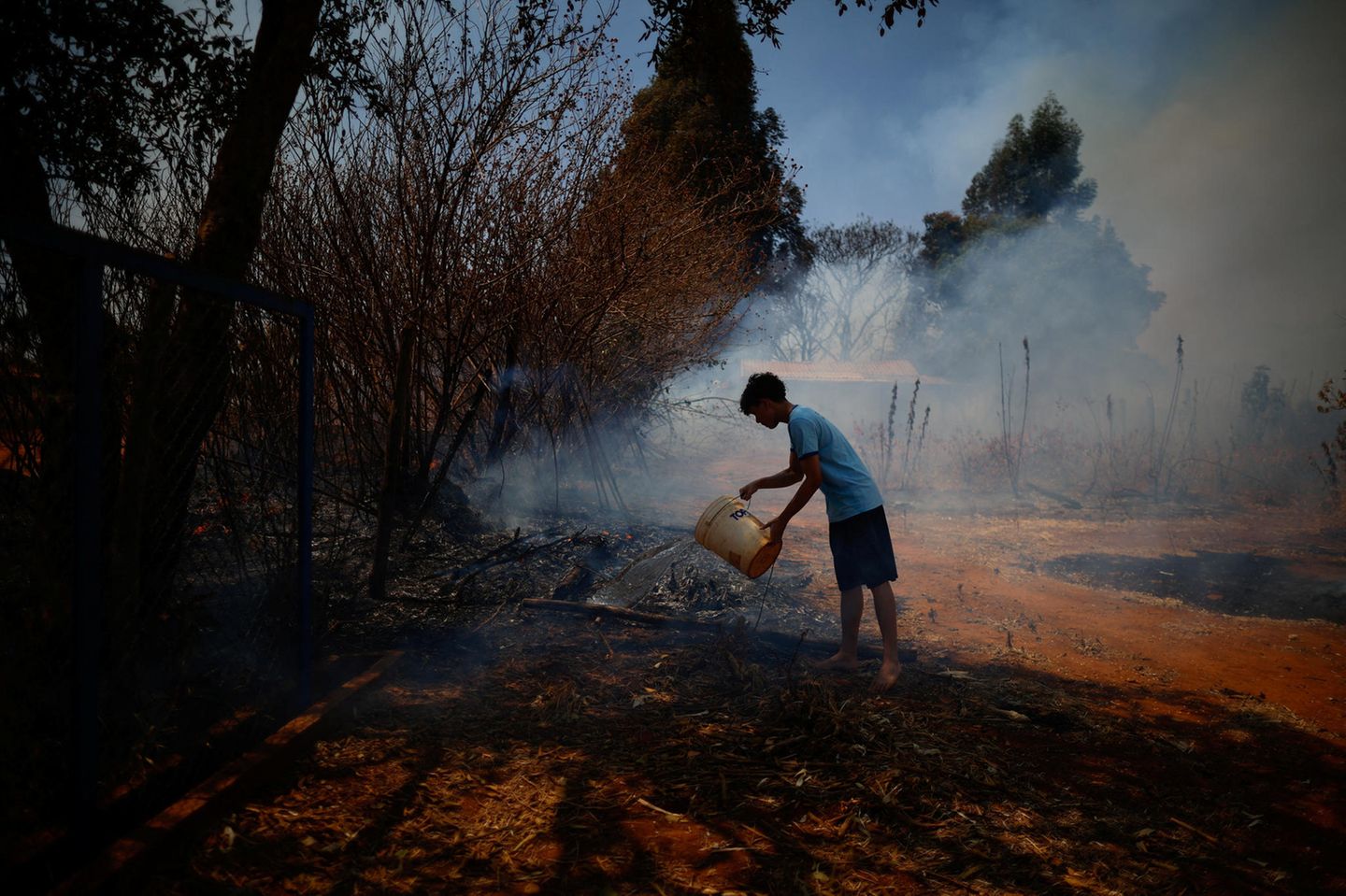 Es wirkt wie ein Tropfen auf den heißen Stein: Ein Mann versucht mit Wasser aus einem Eimer einen kleineren Brandherd in einem Waldgebiet in der Nähe von Brasília zu löschen. Währenddessen toben in weiten Teilen Brasiliens die schlimmsten Waldbrände seit Jahren