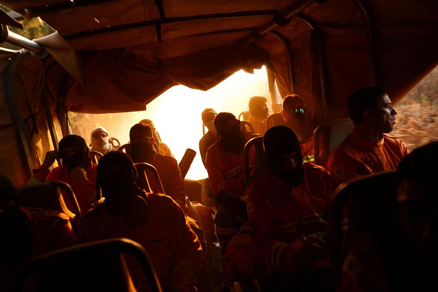 Mitarbeiter der Feuerwehr sitzen in einem Bus und fahren zu ihrem Einsatzort, um die gewaltigen Waldbrände, die seit Tagen im Nationalpark Brasília herrschen, unter Kontrolle zu bringen – oft unter Einsatz ihres Lebens