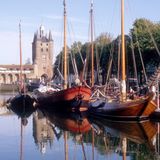 Hafen mit alten Schiffen und Schloss im Hintergrund