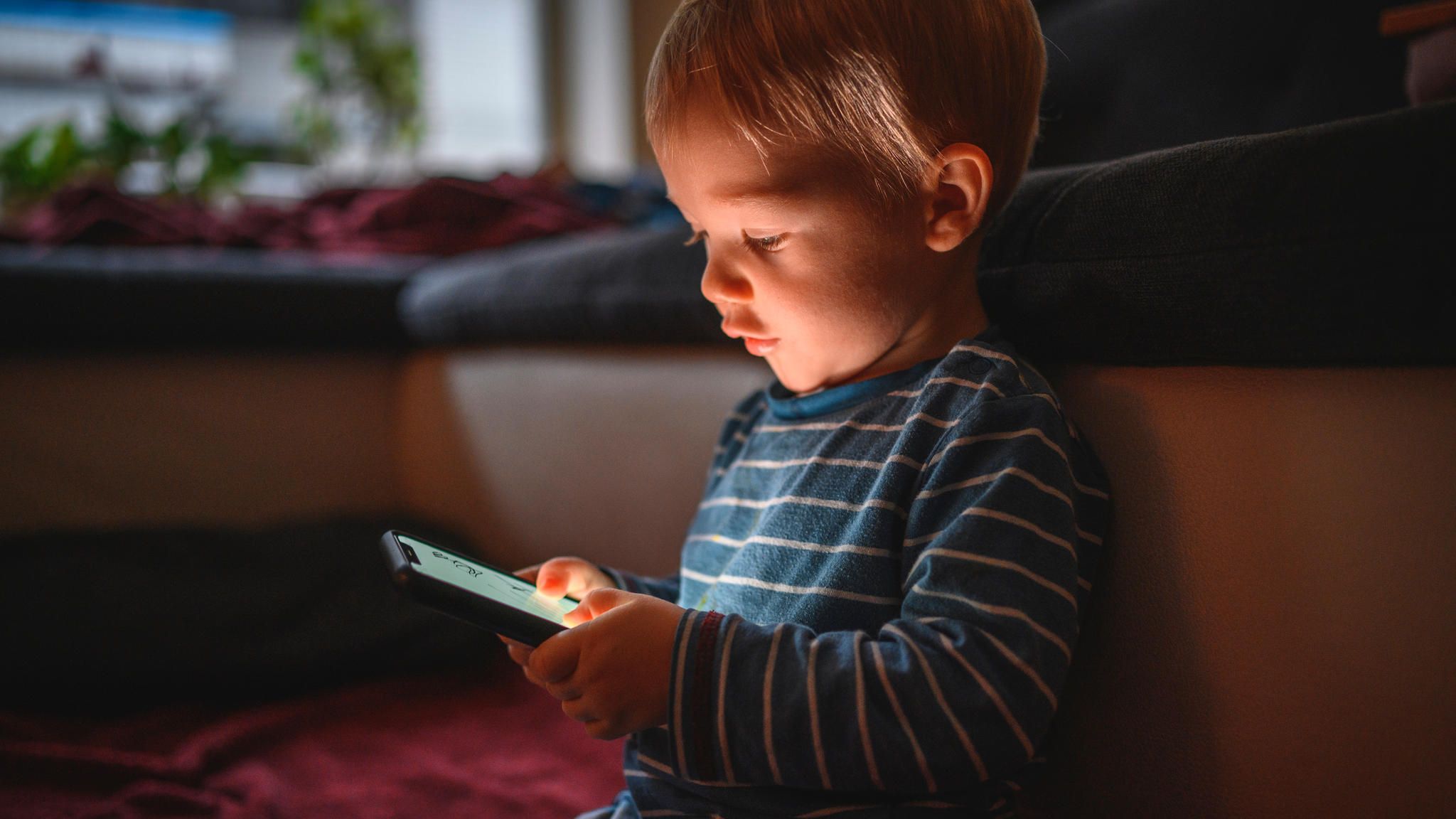 Kleinkind spielt mit Smartphone