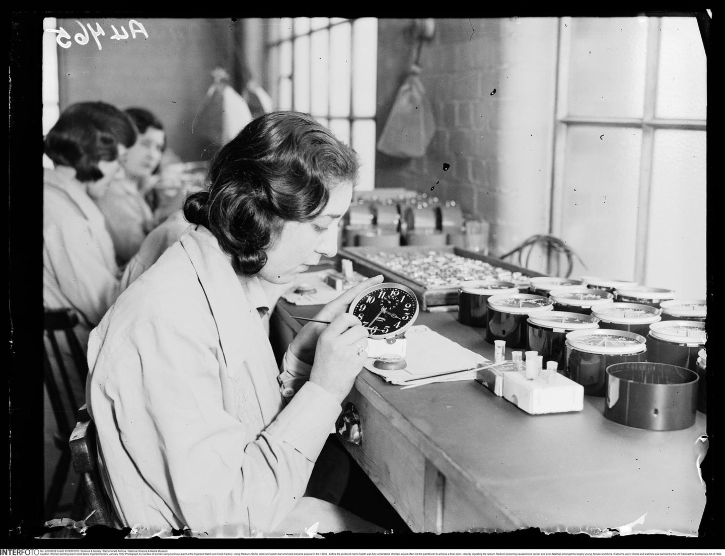 Frauen bemalen Uhren mit radioaktiver Farbe im Januar 1932