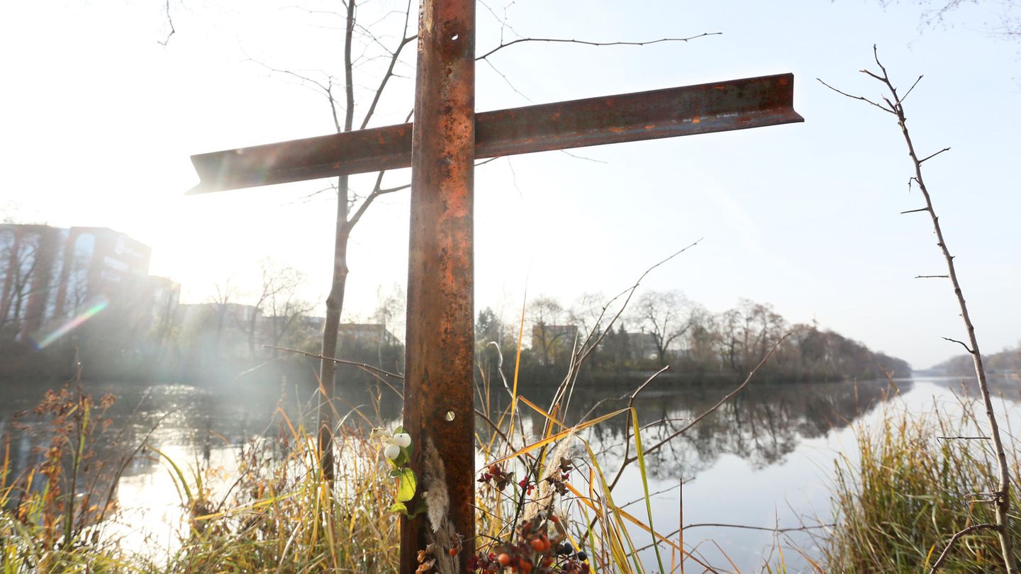 Metallkreuz steht am Wasser
