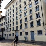 Mann auf Fahrrad vor gelbem Industriehaus