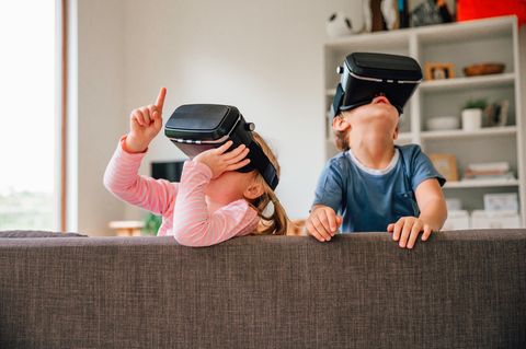 Kinder mit Headsets spielen auf dem Sofa