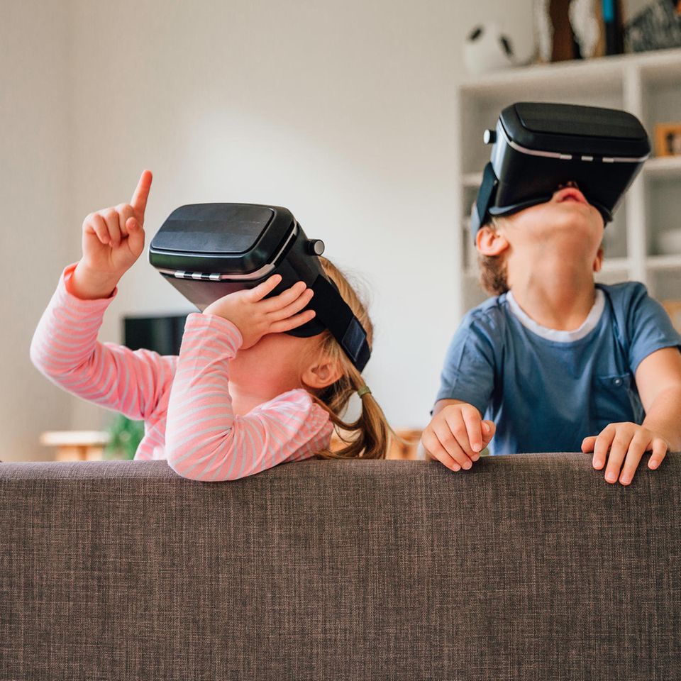 Kinder mit Headsets spielen auf dem Sofa