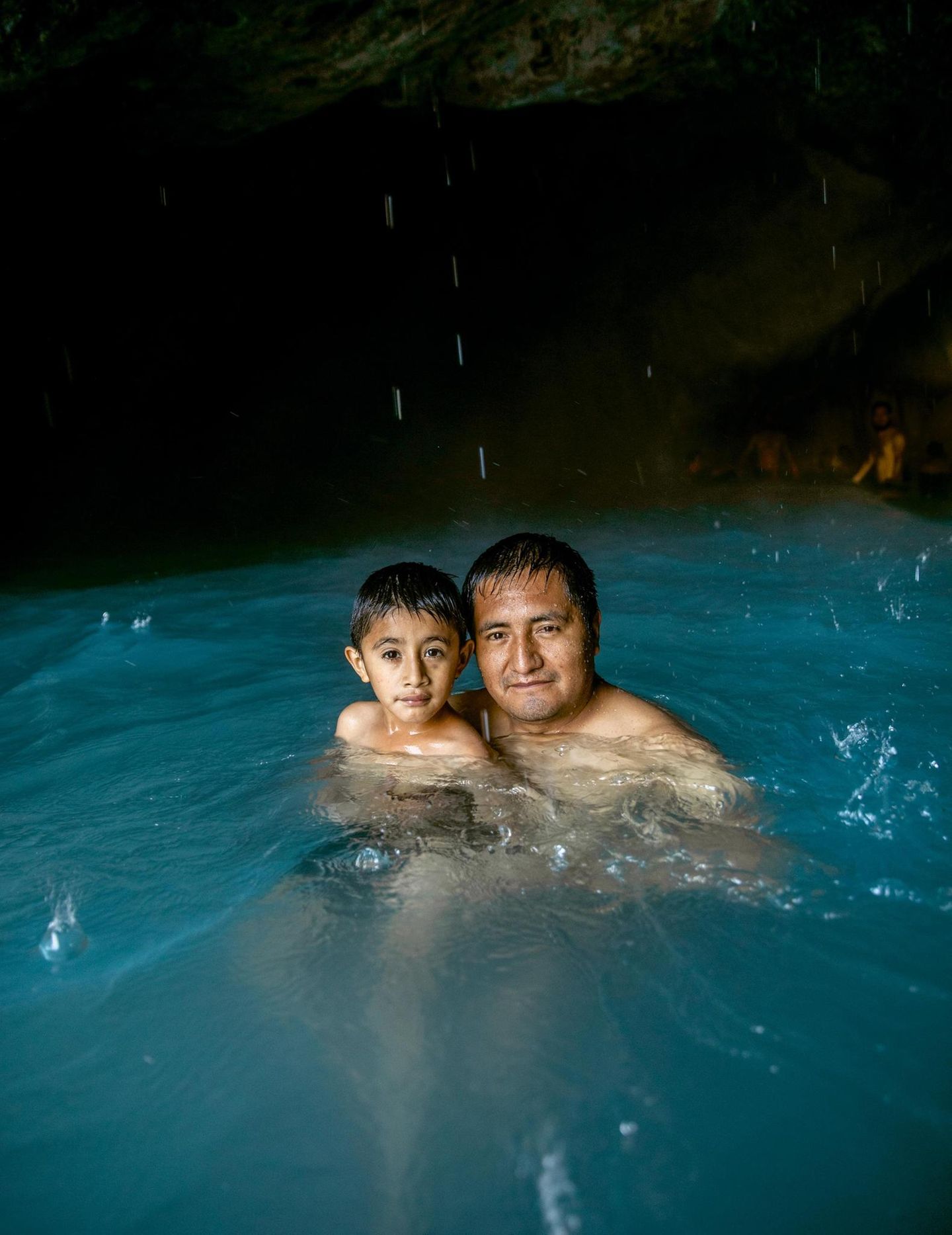 Kind und Mann in einer Badegrotte in Grutas Tolantongo, Mexiko