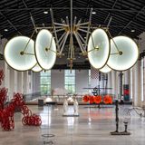 Lichtskulptur hängt an der Decke einer großen Maschinenhalle