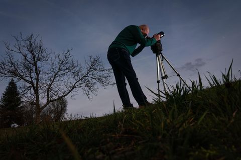 Hansjürgen Köhler mit seinem Teleskop auf einer Wiese im Odenwald. Seit er vor drei Jahren in den Ruhestand ging, jagt er in Vollzeit UFOs