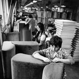 Frauen überziehen Polstermöbel mit Stoff