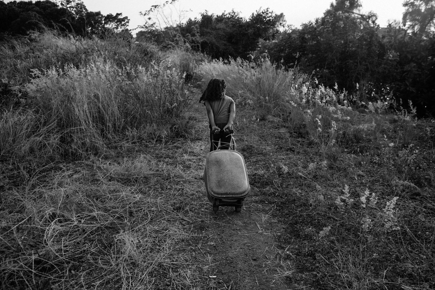 Chiapas Schwarz-weiß Fotografie: Ein Mädchen zieht einen Koffer hinter sich her