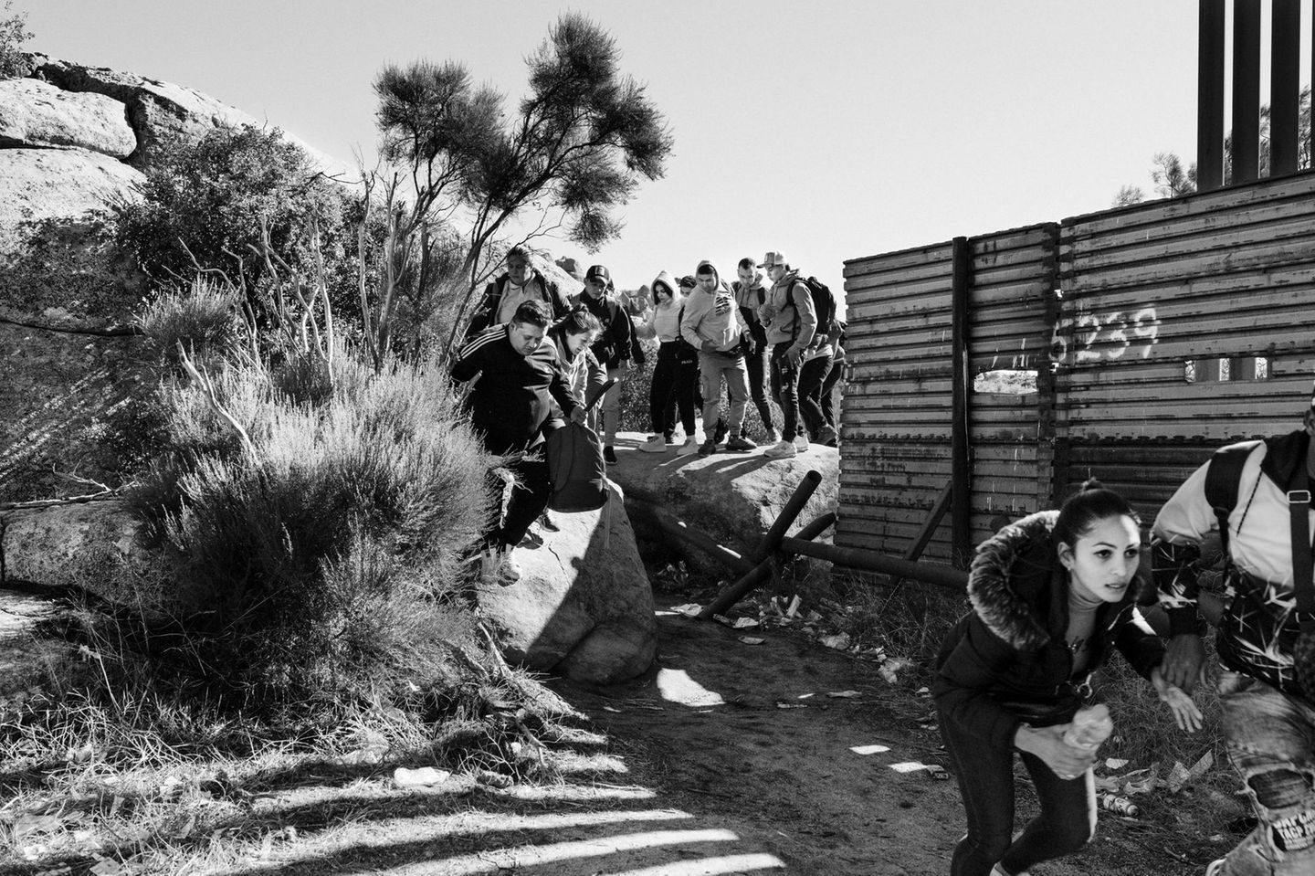 Kalifornien Schwarz-weiß Fotografie: Asylsuchende laufen durch eine Lücke im Grenzzaun zwischen Mexiko und USA