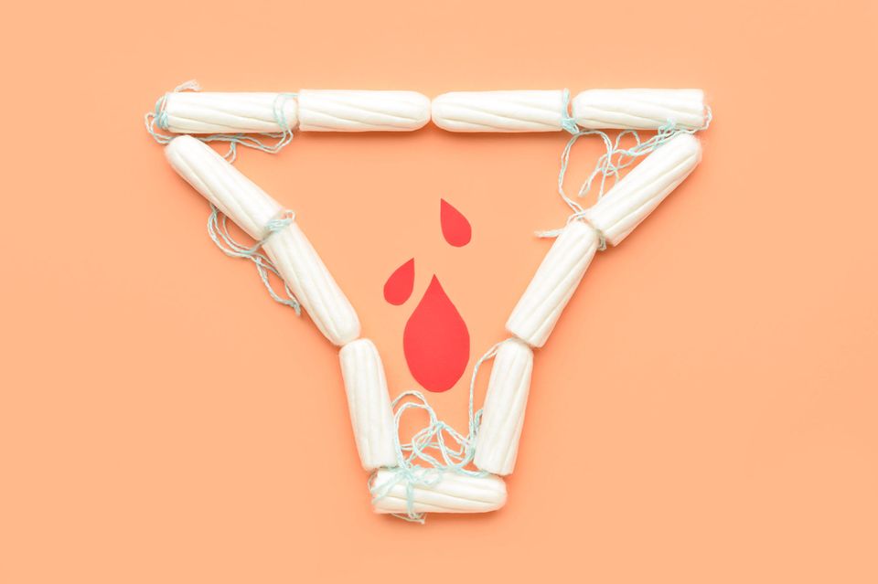 Tampons auf orangefarbenen Hintergrund in Form eines Slips mit Blutstropfen aus Papier innerhalb der Slipform. 1.4183