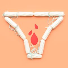Tampons auf orangefarbenen Hintergrund in Form eines Slips mit Blutstropfen aus Papier innerhalb der Slipform.