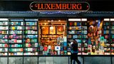Schaufenster voller Bücher, zwei Menschen gehen vorbei