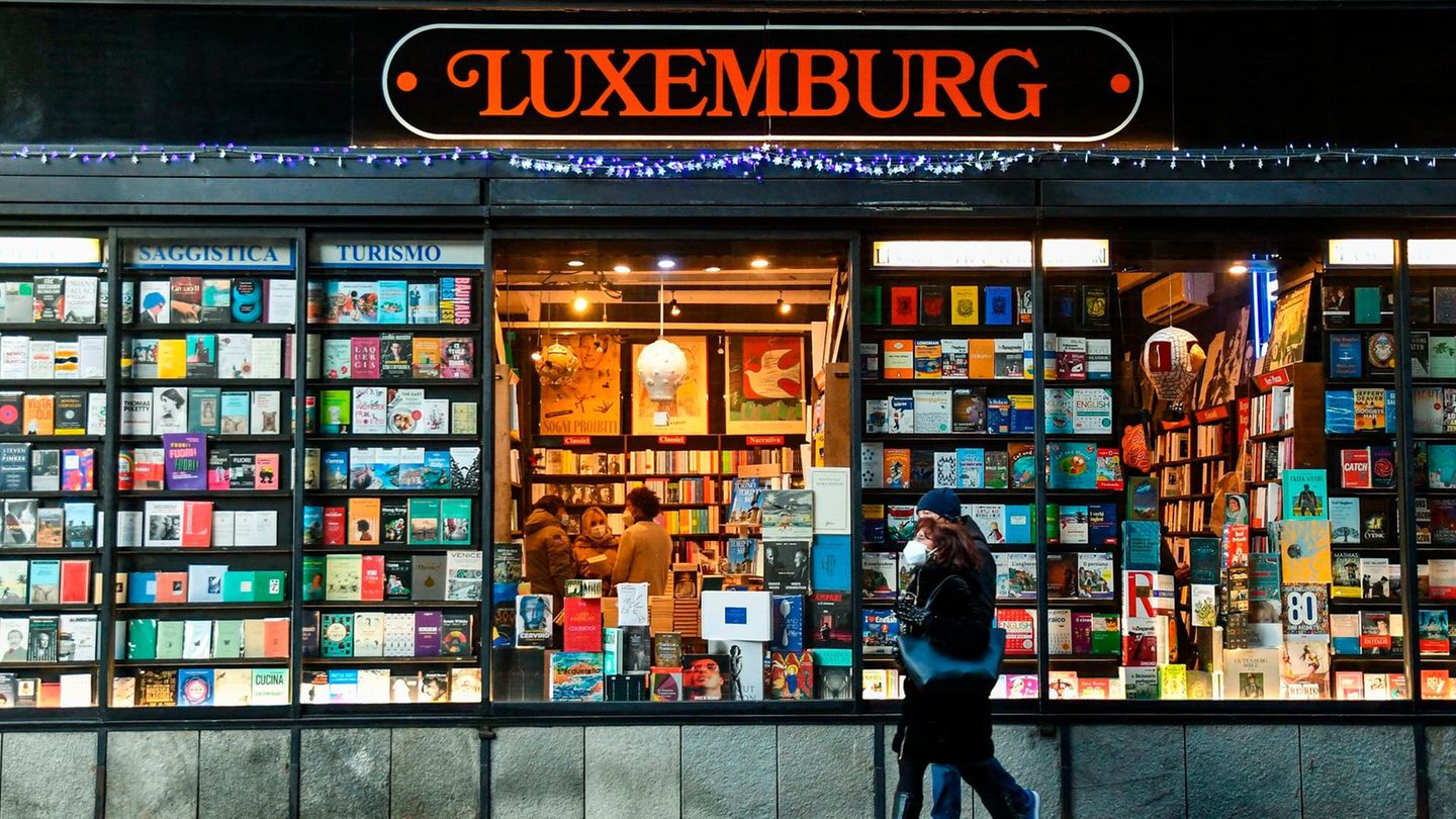 Libreria Internazionale Luxemburg, Turin Schaufenster voller Bücher, zwei Menschen gehen vorbei