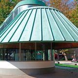 Gigantisches Kupferdach über niedrigem verglasten Pavillon, Außenaufnahme