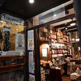 Regale voller Bücher, goldenes Jugendstilbild am Eingang