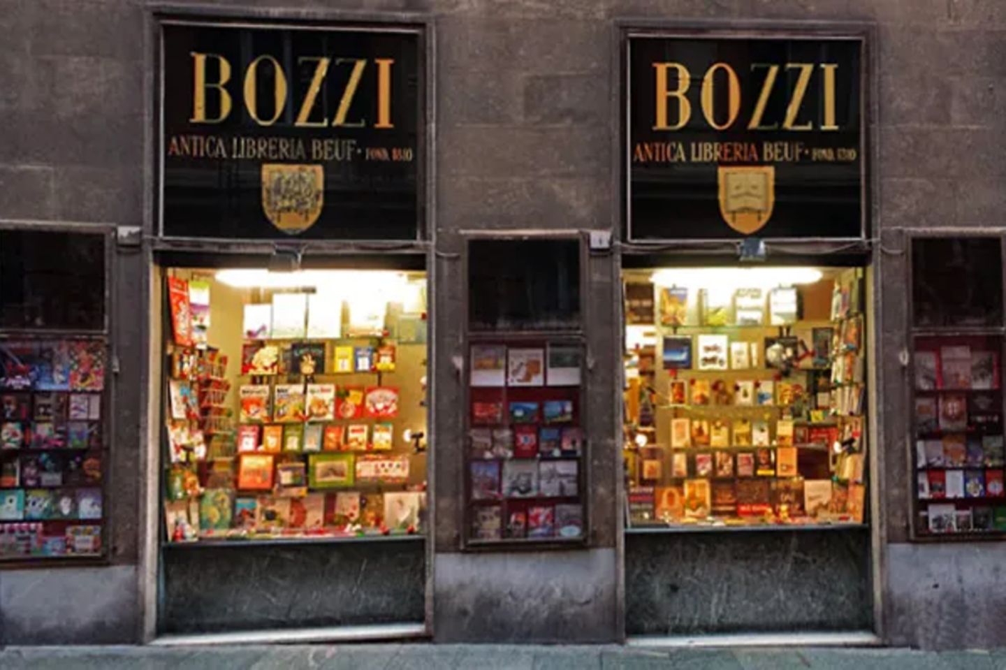 Haus mit zwei beleuchteten Schaufenstern voller Bücher