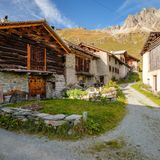 Von der Sonne gebräunte alte Hütten, dahinter Berge