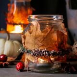 Kerzenglas mit Laub verziert