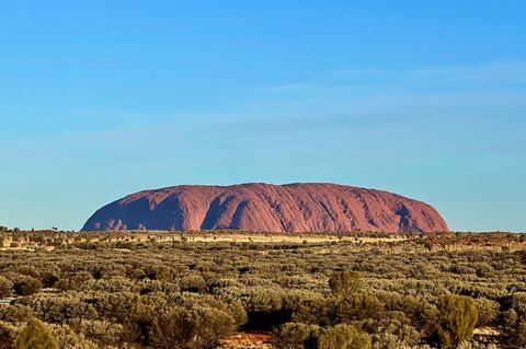 Der Uluru - ein gewaltiger roter Felsen in einer Ebene