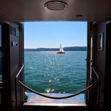 Blick durch ein Fenster eines Schiffs auf See und Segelboot