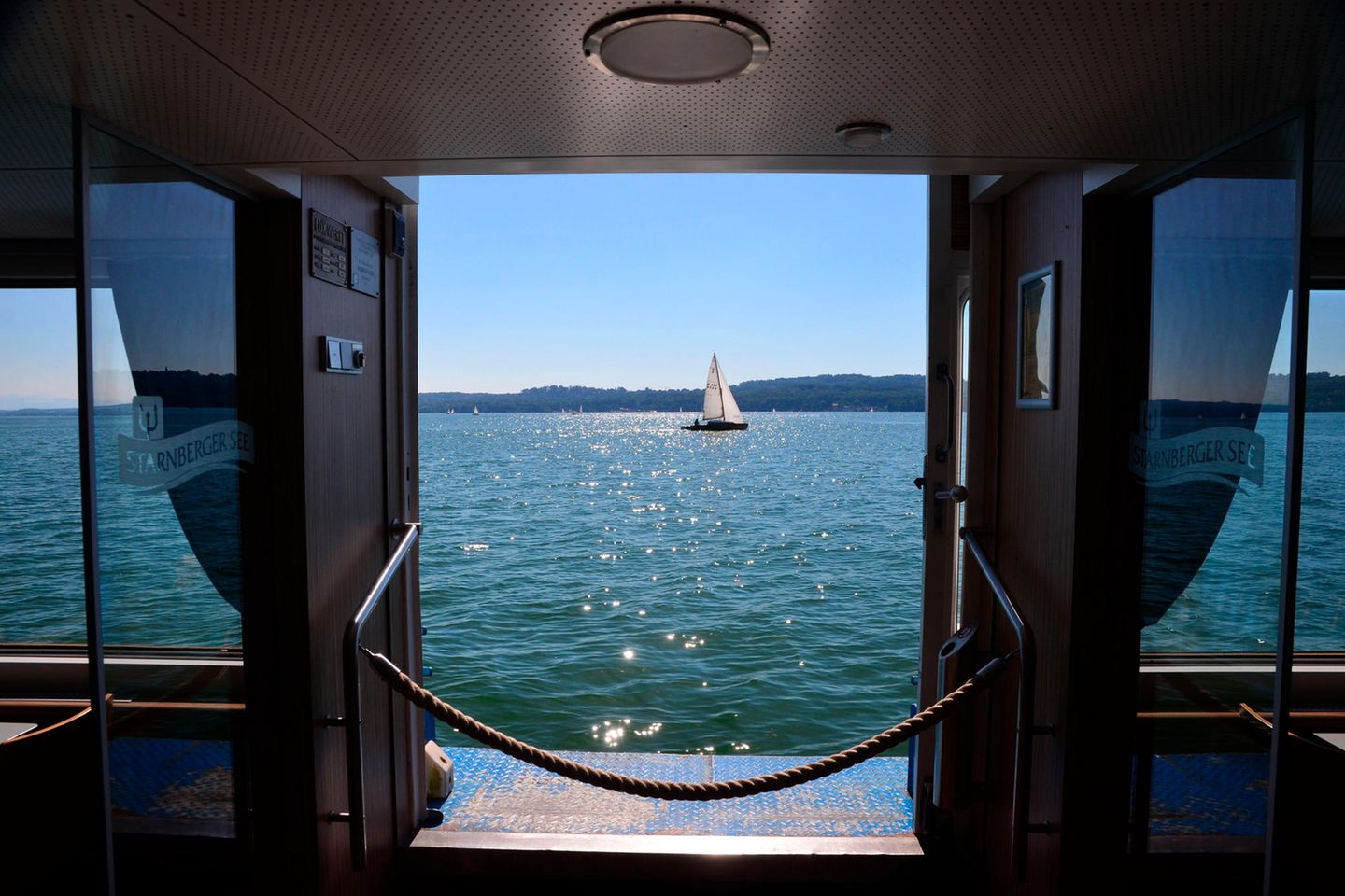 Blick durch ein Fenster eines Schiffs auf See und Segelboot