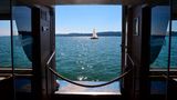 Blick durch ein Fenster eines Schiffs auf See und Segelboot