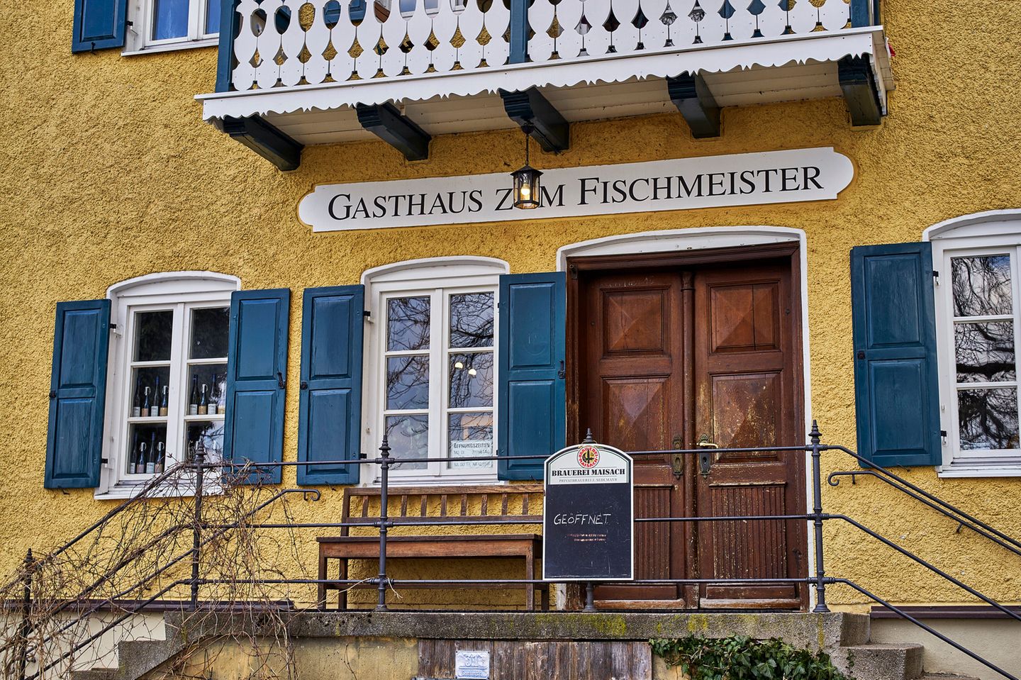 Eingang eines alten Hauses mit Fensterläden und Balkon